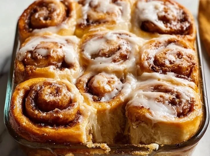 Delicious banana bread cinnamon rolls drizzled with icing on a plate