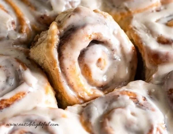 Delicious homemade cinnamon rolls with icing on a wooden table