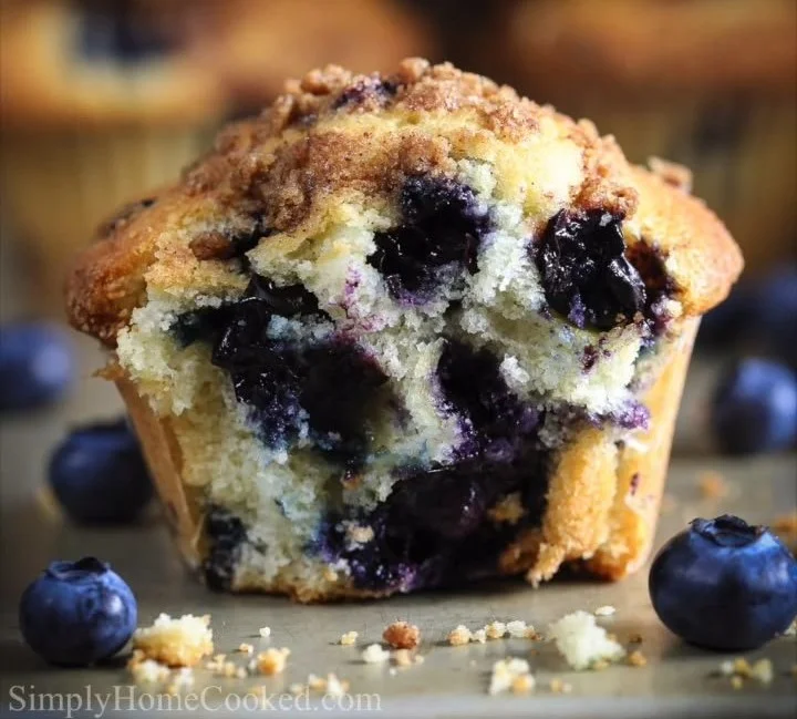Freshly baked blueberry muffins with plump blueberries on a cooling rack