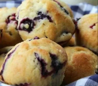 Freshly baked blueberry muffins on a cooling rack.