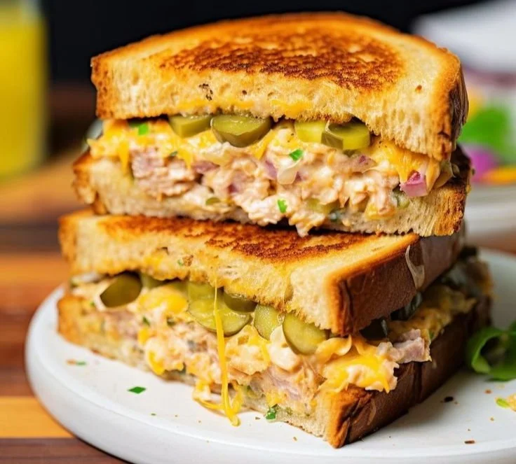 Delicious cheesy tuna melt sandwich with melted cheese and tuna filling.
