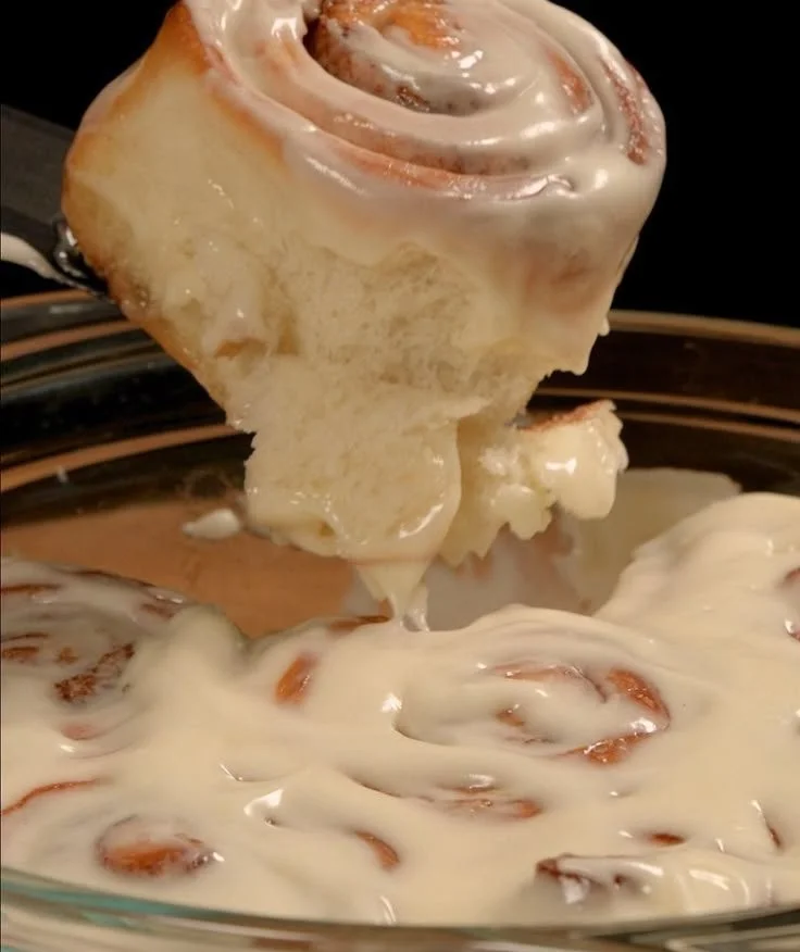 Freshly baked cinnamon rolls topped with creamy icing and sprinkled with cinnamon