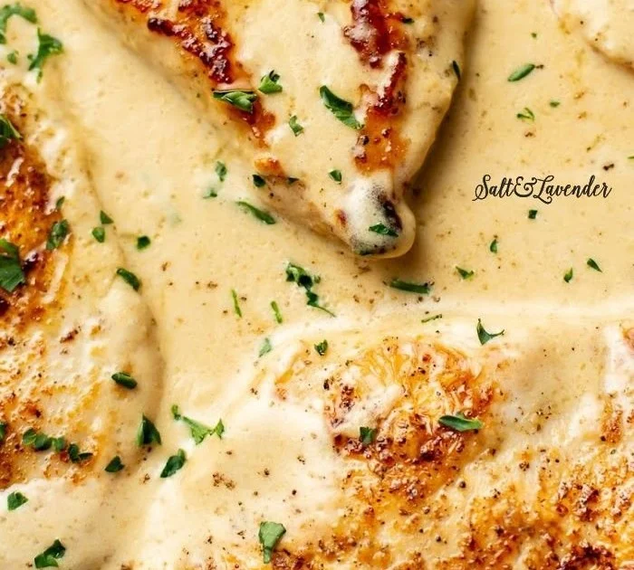 Creamy garlic parmesan chicken garnished with herbs and spices on a plate