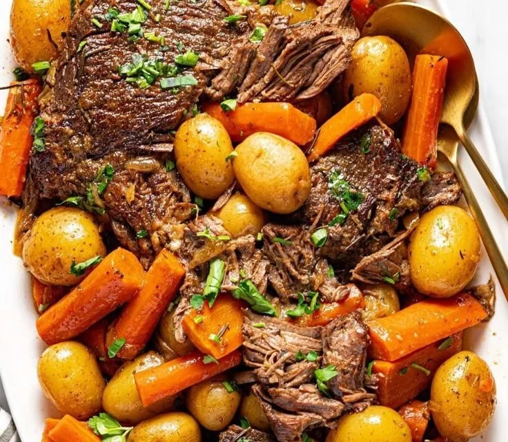 Delicious Crock Pot pot roast served with vegetables and gravy.