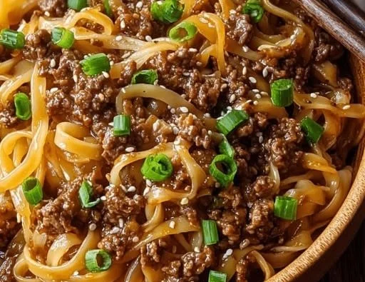 Bowl of savory Mongolian Ground Beef Noodles garnished with green onions