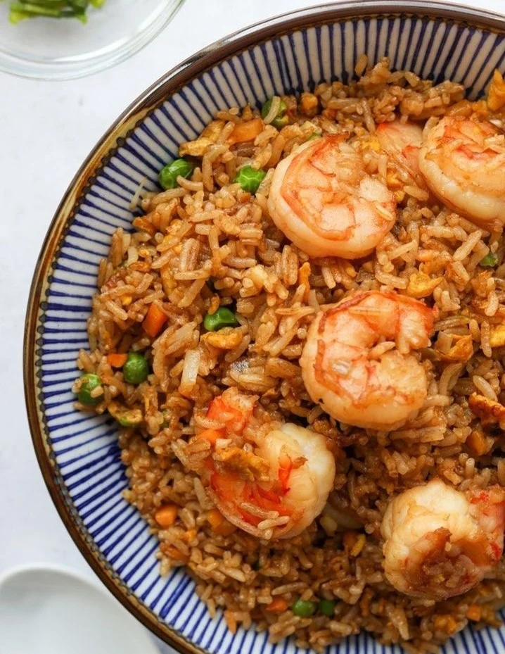 Delicious shrimp fried rice garnished with vegetables and herbs