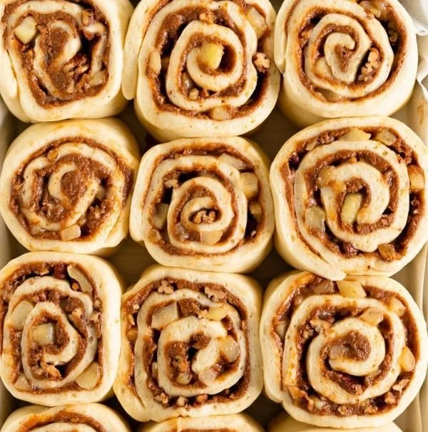 Freshly baked soft apple cinnamon rolls with icing and cinnamon