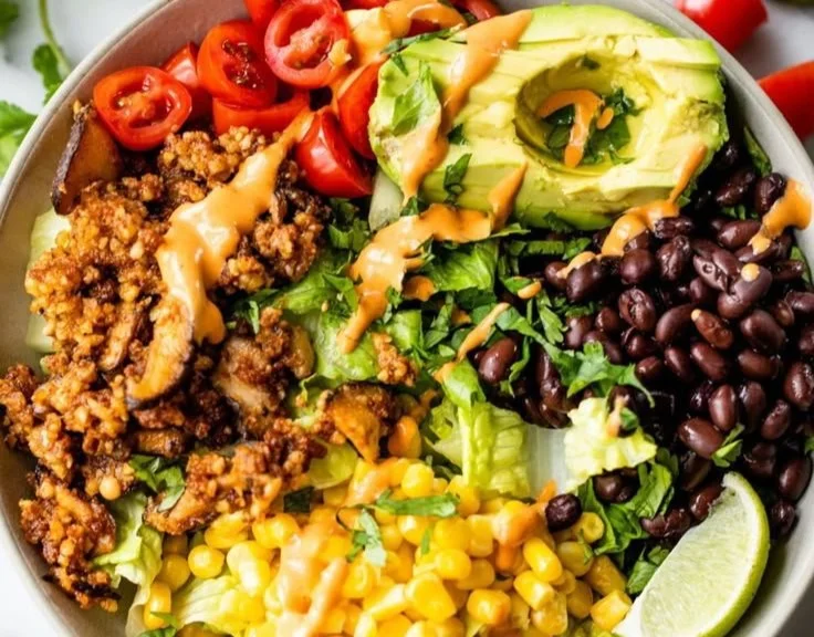 Colorful vegan taco salad with fresh vegetables and toppings on a plate