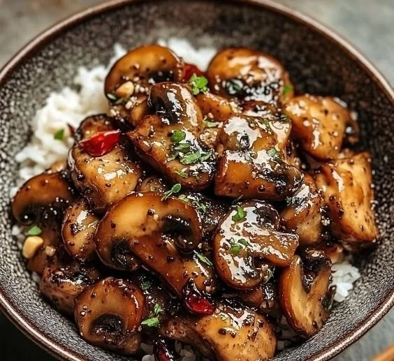 Delicious black pepper chicken with sautéed mushrooms served on a plate.