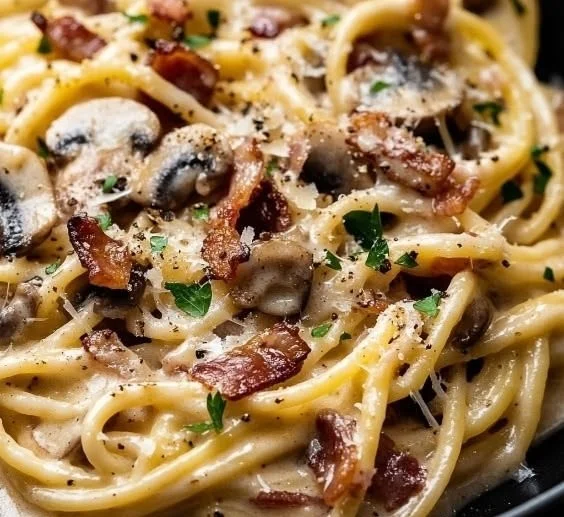 Plate of creamy bacon mushroom pasta with herbs and Parmesan cheese