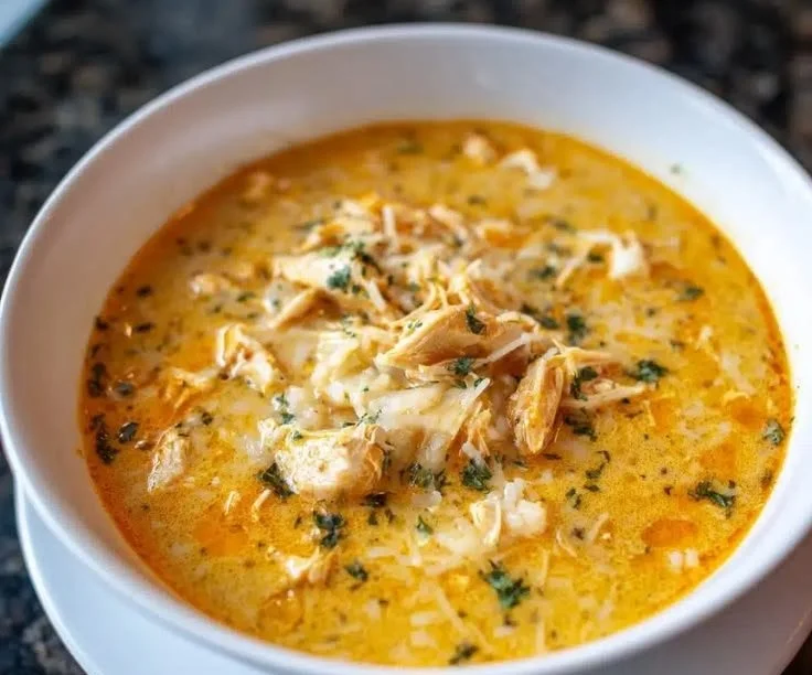 Bowl of creamy Parmesan chicken soup with herbs and spices