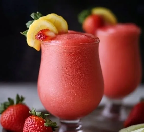 Glass of easy frozen strawberry lemonade with fresh strawberries