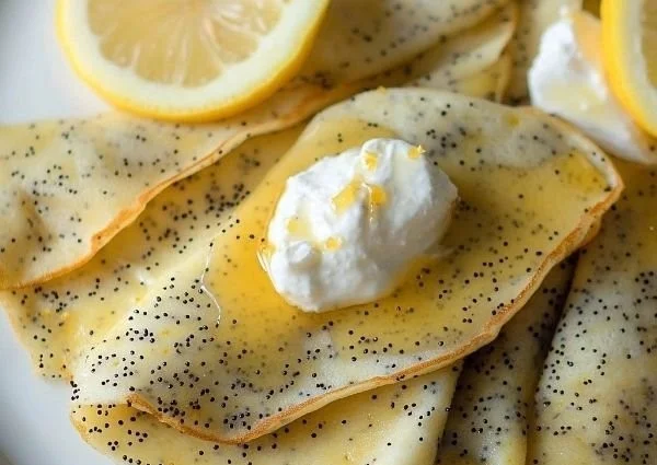 Low-carb poppyseed lemon crepes served on a plate with fresh berries