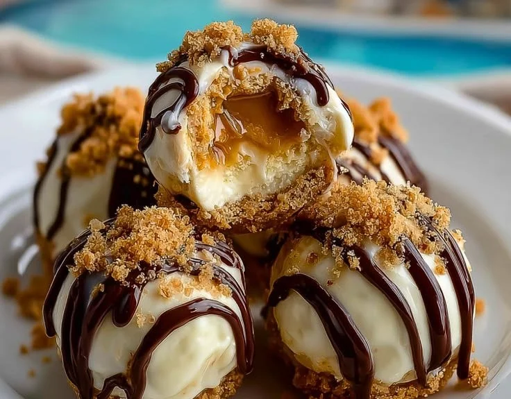No-bake peanut butter cheesecake balls on a plate garnished with chocolate drizzles