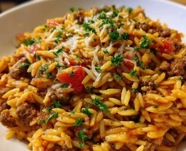One-Pan Ground Beef Orzo Bake topped with cheese and herbs