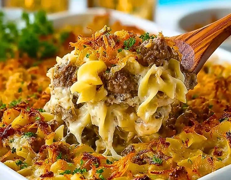 Simple French onion beef casserole topped with cheese and herbs in a baking dish