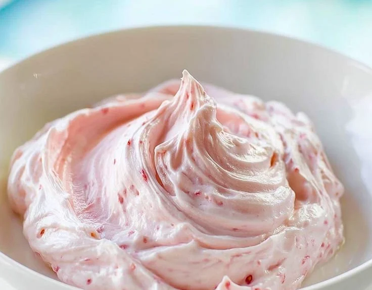 Strawberry marshmallow frosting spread on a cupcake