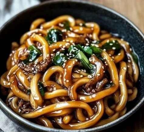 Delicious Yaki Udon noodles served with vegetables and sauce on a plate.