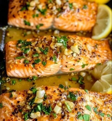 Baked salmon fillet drizzled with honey garlic butter sauce on a plate.
