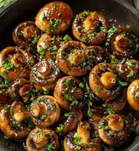 Garlic butter mushrooms drizzled with soy glaze on a plate