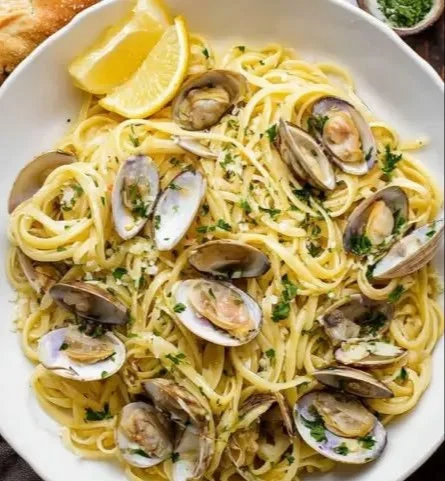Plate of linguine topped with rich clam sauce, garnished with parsley.