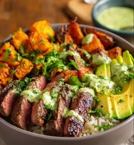 Steak and Sweet Potato Bowl garnished with fresh herbs