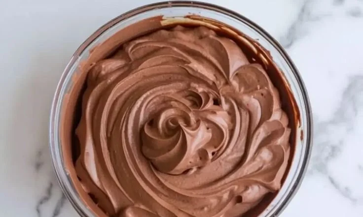 Delicious chocolate mousse cake with creamy filling showcased on a dessert table.
