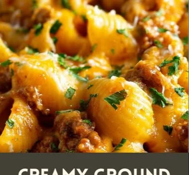 Creamy ground beef shells casserole topped with cheese and herbs