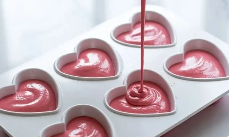 Heart-shaped raspberry mousse dessert garnished with fresh raspberries