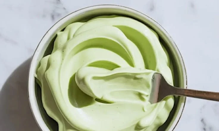 Pistachio Mascarpone cake filling in a decorative bowl with fresh pistachios